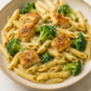 a plate of penne pasta with chinks of chicken breast and broccoli florets in a garlic parmesan sauce for dinner ideas