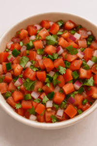 a bowl of fresh tomatoes onion and peppers called pico de gallo