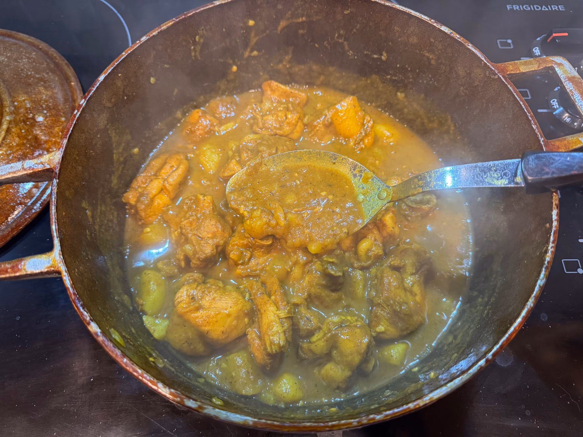 curry chicken cooking in a dutch pot