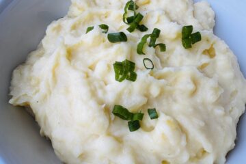 A close up of mashed potatoes topped with green onion