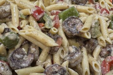 overhead closeup shrimp and penne pasta with sprinkles of parmesan cheese