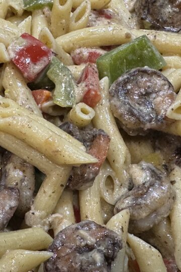 overhead closeup shrimp and penne pasta with sprinkles of parmesan cheese