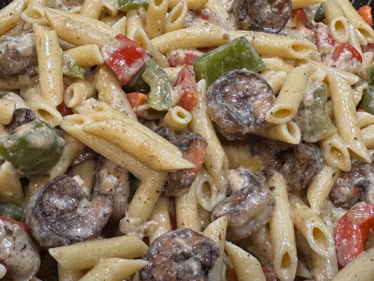 overhead closeup shrimp and penne pasta with sprinkles of parmesan cheese