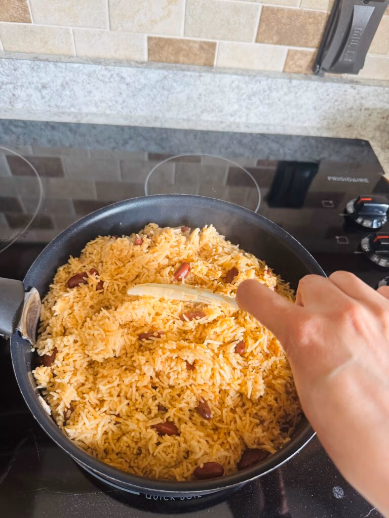 finished pot of cooked jamaican rice and beans being fluffed