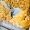 A spoonful of golden creamy baked three cheese macaroni and cheese with ritz topping