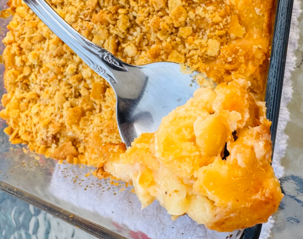 A spoonful of golden creamy baked three cheese macaroni and cheese with ritz topping