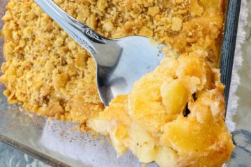 A spoonful of golden creamy baked three cheese macaroni and cheese with ritz topping