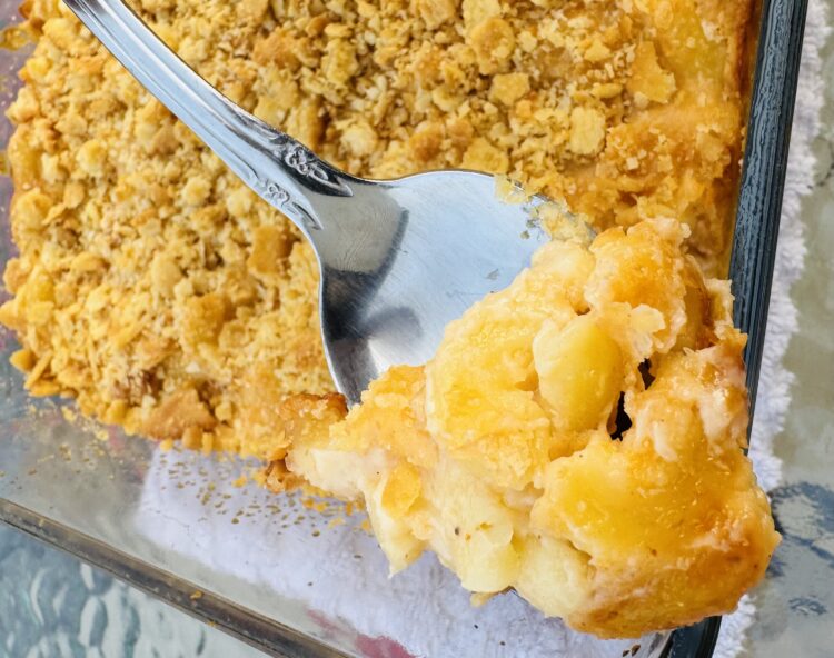 A spoonful of golden creamy baked three cheese macaroni and cheese with ritz topping