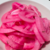 Quick pickled red onions in a white bowl