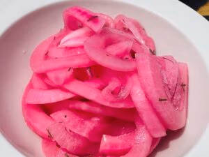 Quick pickled red onions in a white bowl