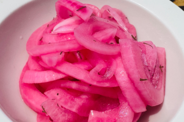 Quick pickled red onions in a white bowl