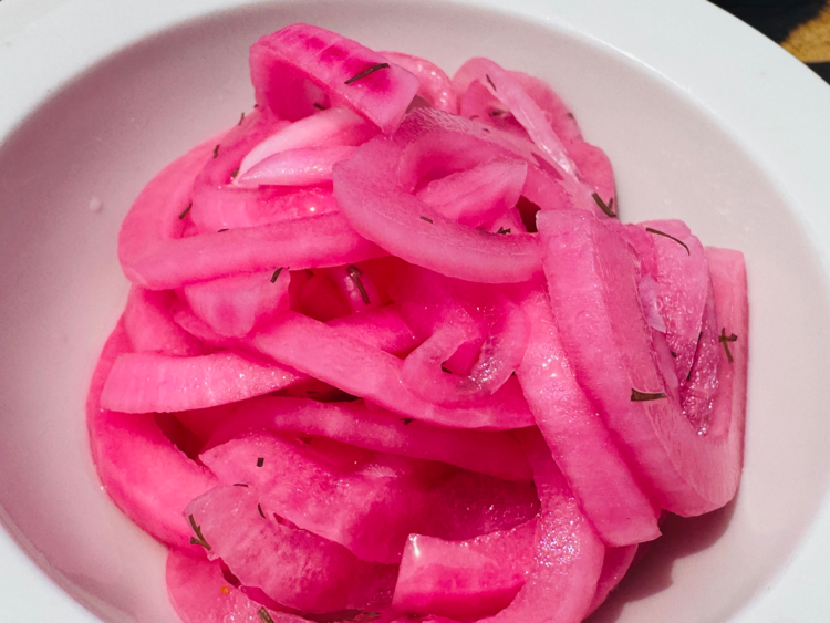 Quick pickled red onions in a white bowl