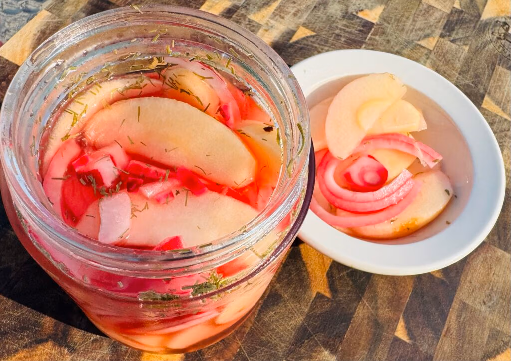 A jar of pickled apples and red onions