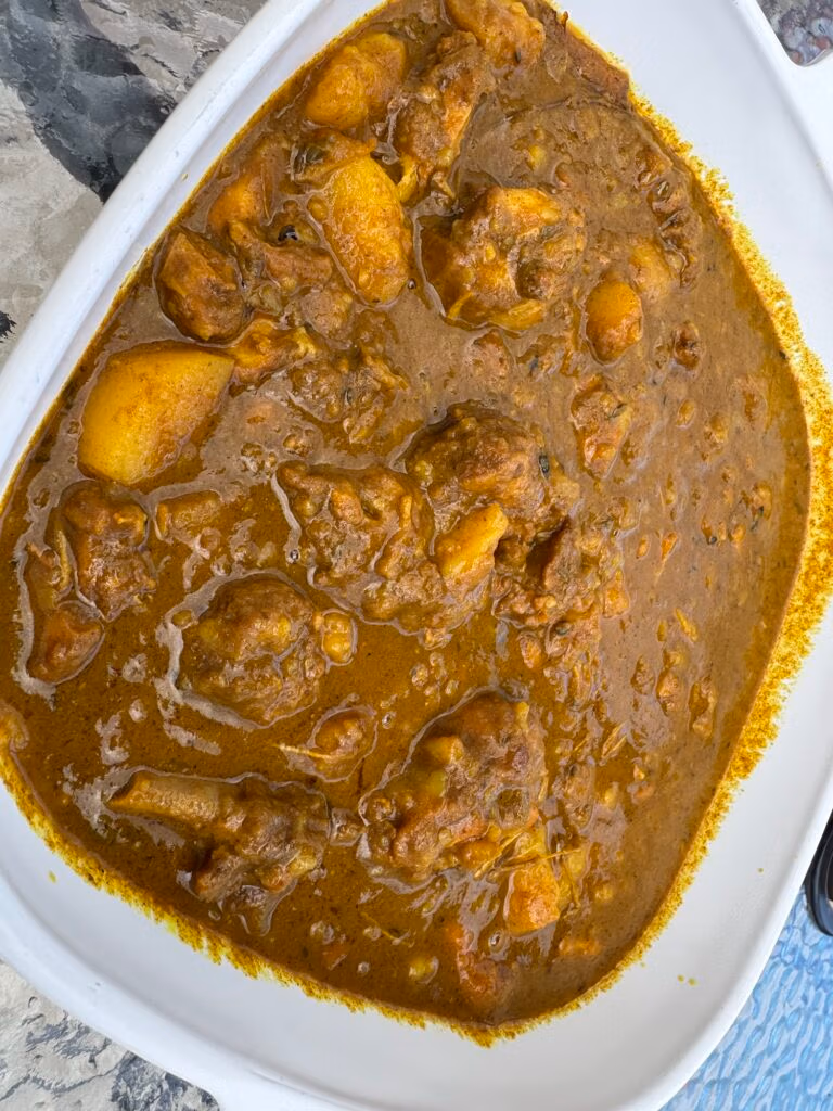 a white serving dish with curry chicken made in the instant pot