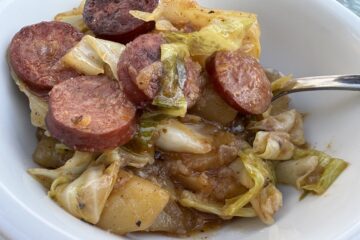 tender sauteed cabbage and smoked sausage in a white bowl
