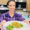 Camille of Camilles Comforting Cuisine holding a plate sauteed bok choy with white rice.